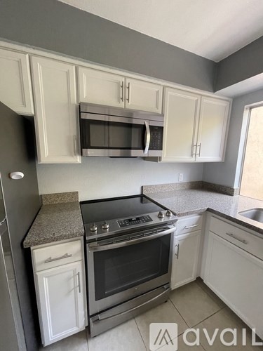 A kitchen with white cabinets and a granite countertop.