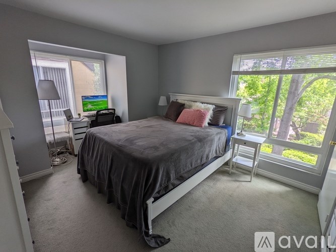 A bedroom with a bed, desk, and chair.