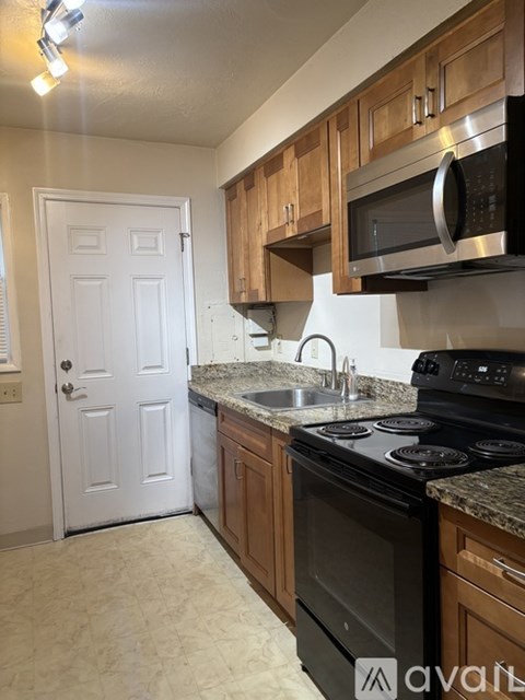 A kitchen with a black stove top oven and a white door.
