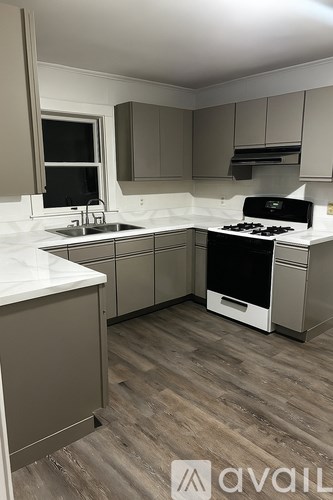 A kitchen with a white countertop and a stove top oven.