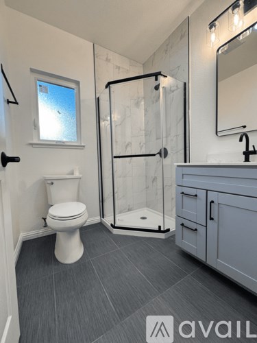 A bathroom with a toilet, sink, and shower.