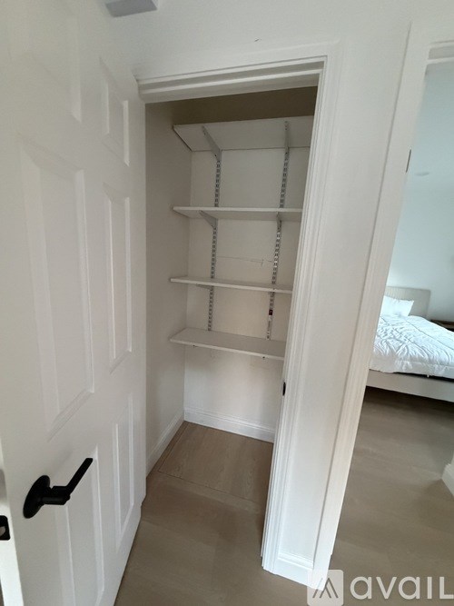 A bedroom with a bed, a window, and a wall hanging.