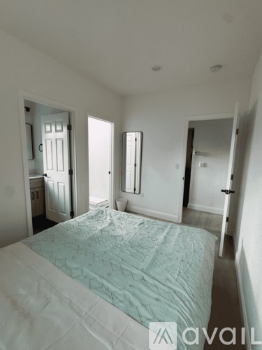 A bedroom with a bed, dresser, and mirror.