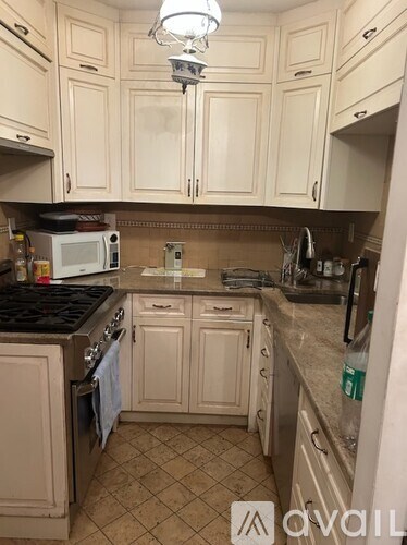A kitchen with white cabinets and a black stove top.