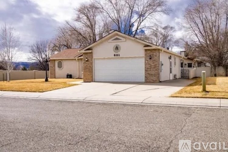 A house with a garage and a driveway in front of it.