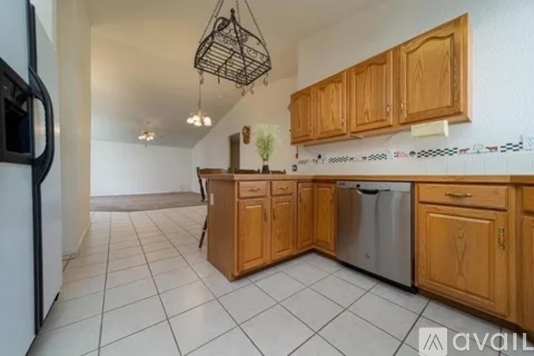 A kitchen with wooden cabinets and a white tile floor.