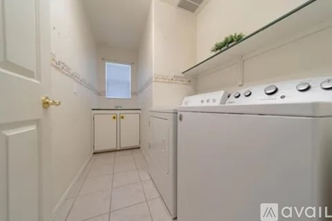 A white kitchen with a stove and a window.