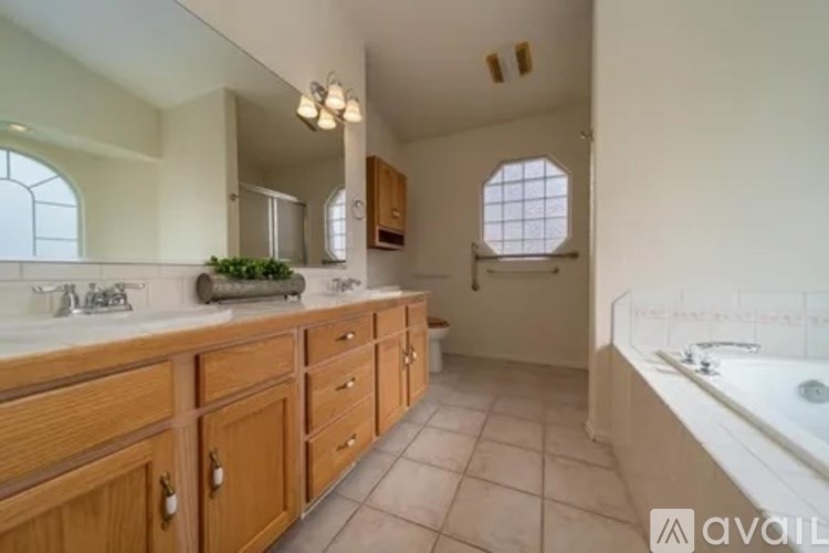 A bathroom with wooden cabinets and a large mirror.