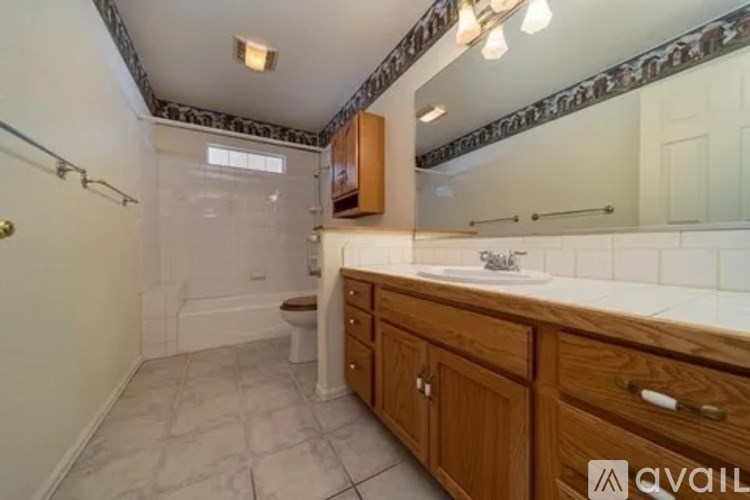 A bathroom with a toilet, sink, and mirror.