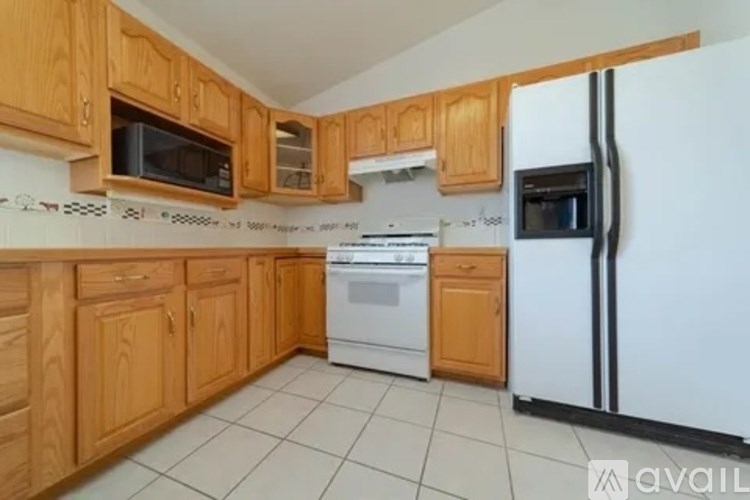 A kitchen with wooden cabinets and a white refrigerator.