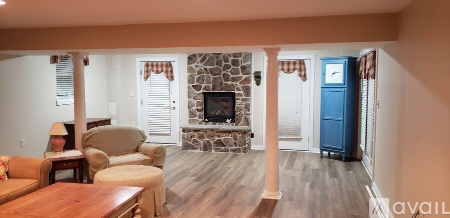 A living room with a stone fireplace and a blue cabinet.