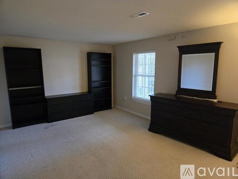 A bedroom with a large bed and a window.