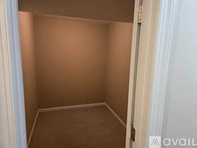 A small, empty room with a carpeted floor and white walls.