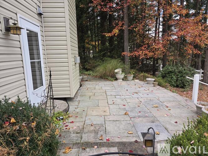 A small patio with a white door and a lamp.