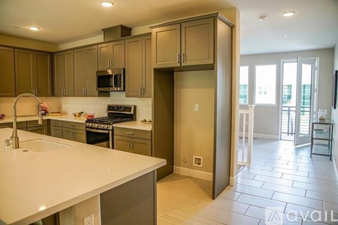 A kitchen with a white counter top and brown cabinets.