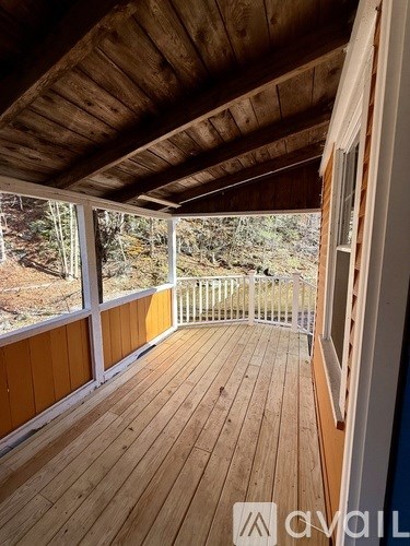 A wooden deck with a railing and a view of the outdoors.