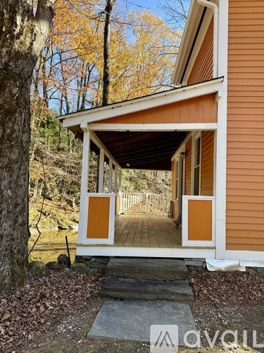 A wooden house with a porch and a white door.