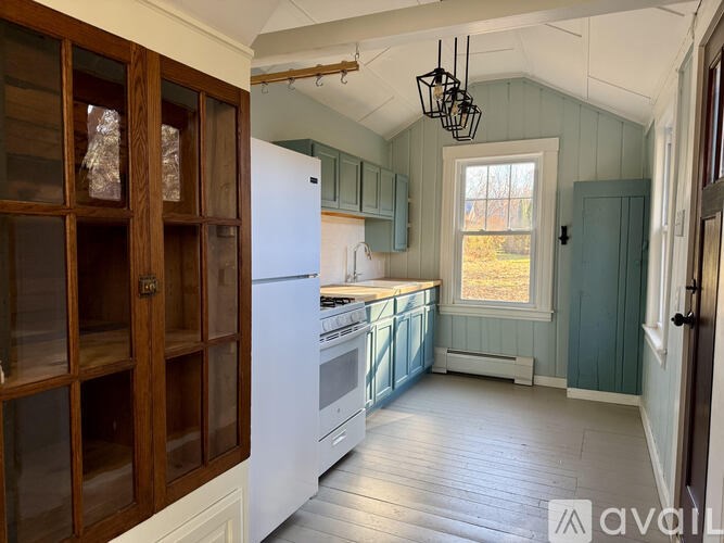 A kitchen with a white refrigerator and wooden cabinets.