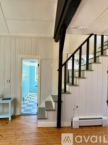 A hallway with a staircase and a bench.