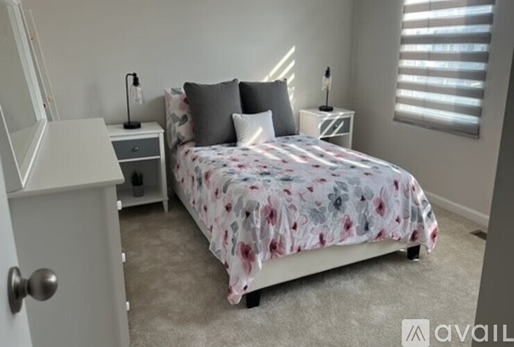 A bedroom with a bed, nightstand, and lamp.