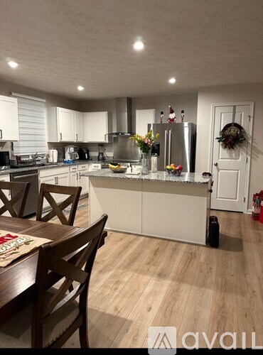 A kitchen with a table and chairs in front of it.