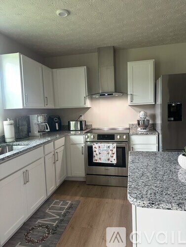A kitchen with granite countertops and stainless steel appliances.
