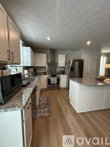 A kitchen with granite countertops and white cabinets.