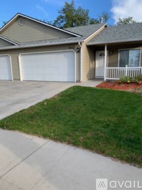 A house with a white garage door and a white fence.