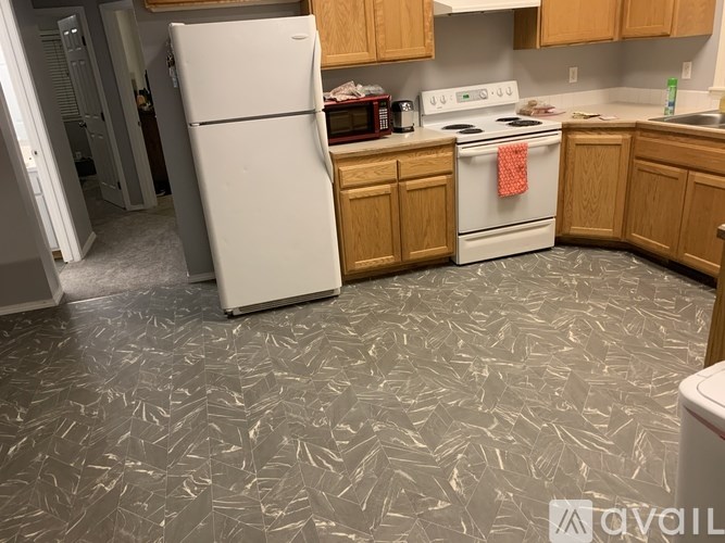 A kitchen with a white refrigerator and a white stove top oven.