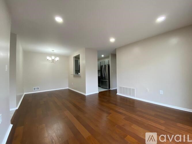 A spacious room with wooden floors and white walls.