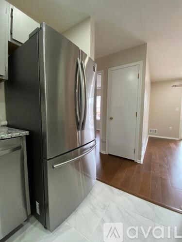 A stainless steel refrigerator in a kitchen with a white countertop.