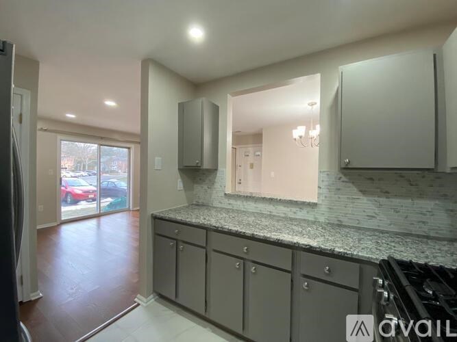 A kitchen with a granite countertop and cabinets.