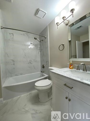 A bathroom with a white toilet, sink, and tub.