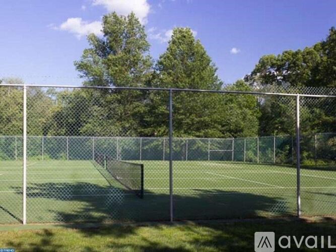 A tennis court enclosed by a chain link fence.