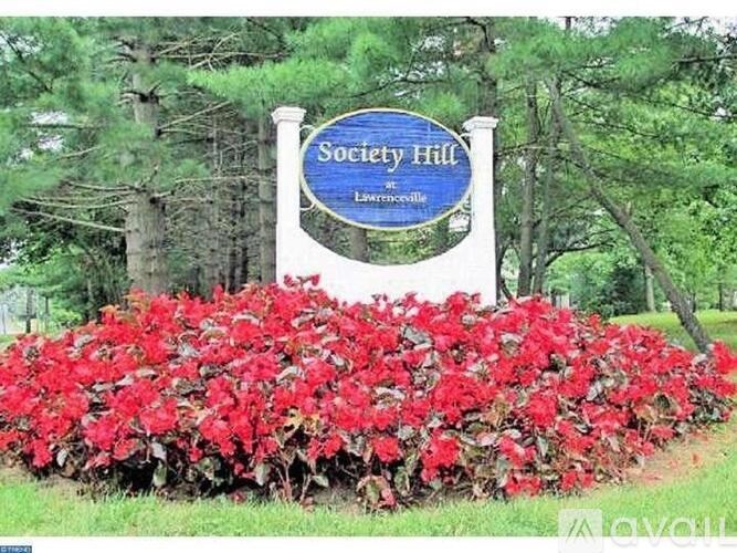 A sign that says Society Hill in front of a bush.