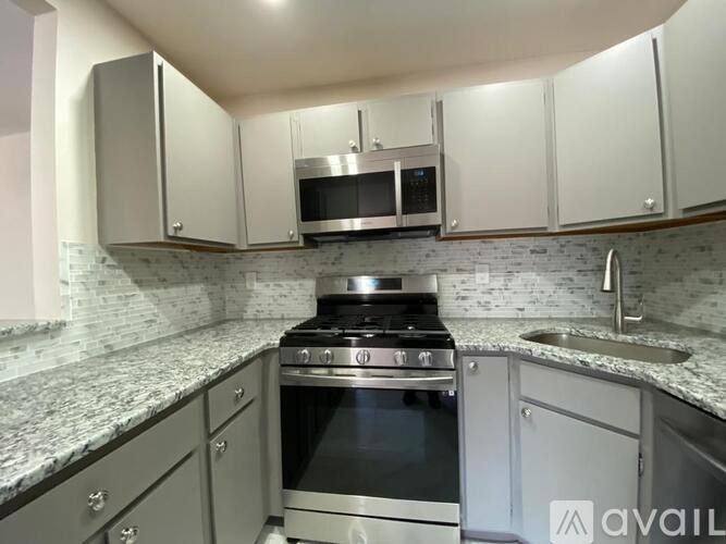 A kitchen with a stove and microwave built into the cabinetry.