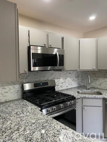 A modern kitchen with a stove top oven and microwave above it.