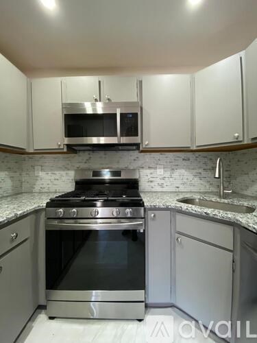 A modern kitchen with a stove top oven and microwave above it.