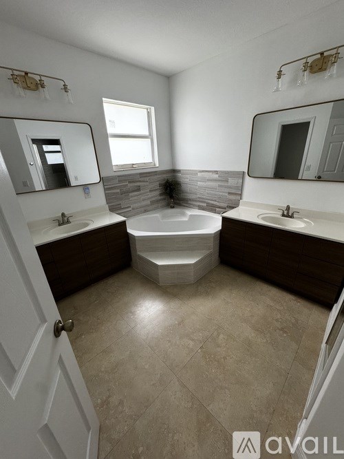 A bathroom with a tub, sink, and mirror.