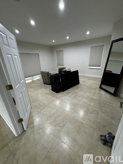 A room with a white door and a tiled floor.