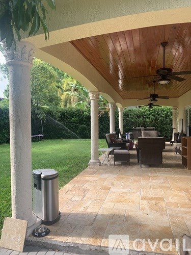 A patio with a table and chairs under a roof.