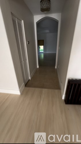 A hallway with a light at the end and a closed door.