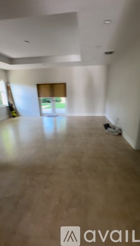 A room with a large window and a wooden floor.