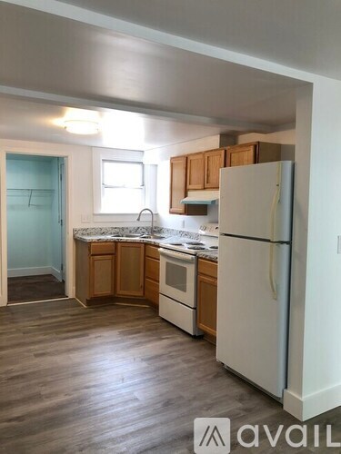 A kitchen with wooden cabinets and a white refrigerator.