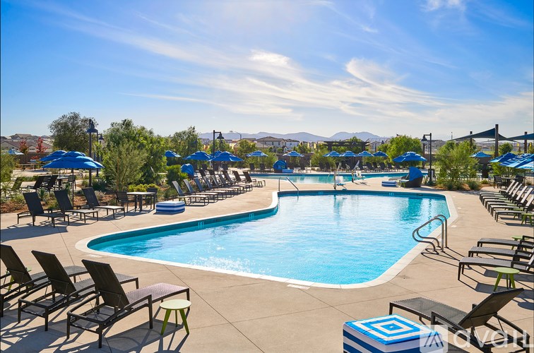 A large outdoor swimming pool surrounded by lounge chairs and umbrellas.