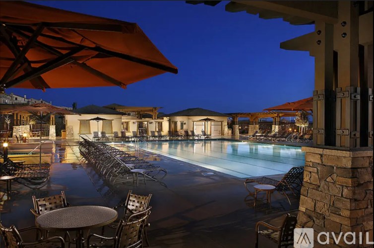 A pool area with tables and chairs and umbrellas is available.