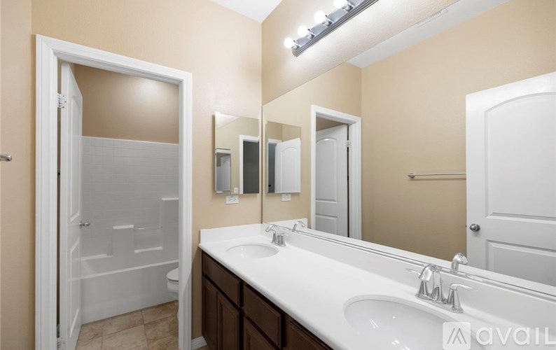 A bathroom with a white sink and a mirror above it.