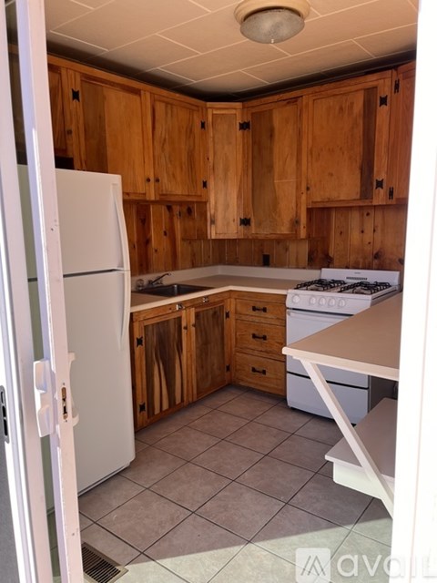 A kitchen with wooden cabinets and a white refrigerator.