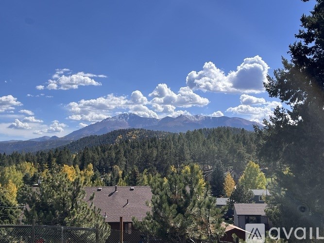 A mountain range is visible in the distance behind a cluster of houses.