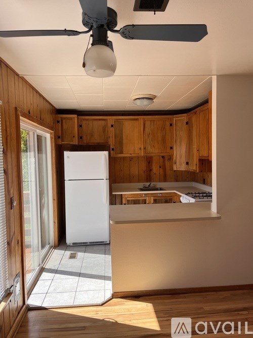 A kitchen with wooden cabinets and a white refrigerator.